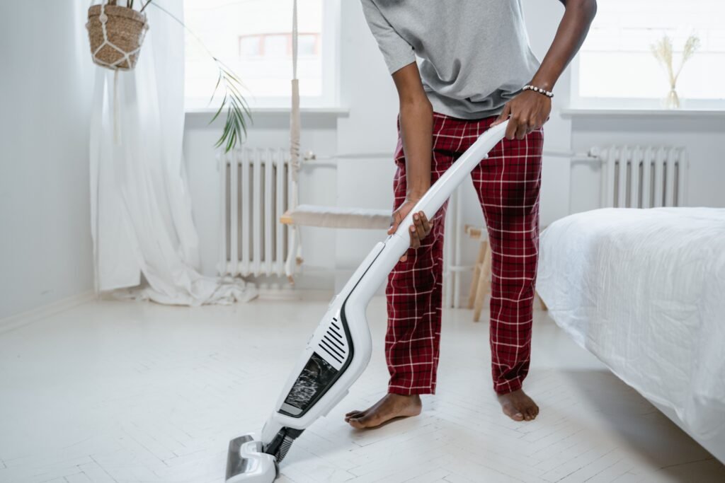 Pessoa usando aspirador vertical sem fio na sala – melhores aspiradores verticais