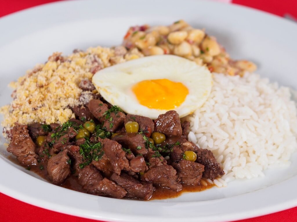 Prato de picadinho de carne com arroz, farofa e ovo, feito na panela de pressão elétrica – melhores panelas de pressão elétricas 2026